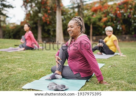 Multiracial women doing yoga exercise with social distance for coronavirus outbreak at park outdoor - Healthy lifestyle and sport concept