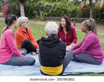 Multiracial women sitting and talking at city park - Multi generational people having fun together - Powered by Shutterstock