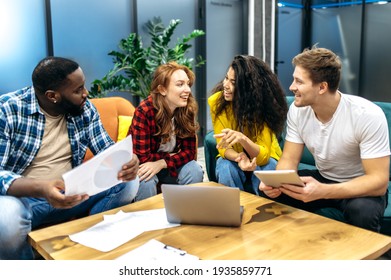 Multiracial young adult colleagues sitting on the sofa, discussing work questions. Happy friendly male and female employees having a conversation, talking about corporate project, teamwork concept - Powered by Shutterstock