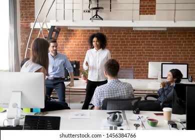 Multiracial young colleagues brainstorm in coworking space, talk discussing business ideas together, diverse millennial employees speak during informal briefing in modern office. Cooperation concept - Powered by Shutterstock