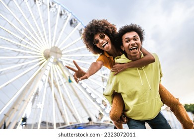 Multiracial young couple of lovers dating at theferry wheel in the amusement park - People with mixed races having fun outdoors in the city- Friendship, releationship and lifestyle concepts - Powered by Shutterstock