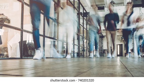 Multiracial young creative people in modern office. Successful hipster team in coworking. Businesspeople walking in the corridor of an business center. Motion blur.