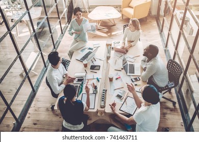 Multiracial young creative people in modern office. Group of young business people are working together with laptop, tablet, smart phone, notebook. Successful hipster team in coworking. Freelancers - Shutterstock ID 741463711