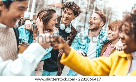 Multiracial young friends having fun walking on city street - University students laughing together outside college - Life style concept with guys and girls hanging out 