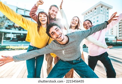 Multiracial Young People Group With Hands Up Smiling At Camera Together - Happy Friends Hanging Out On City Street - Friendship Concept With Guys And Girls Having Fun Outside