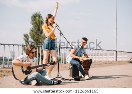 Multiracial young people performing singing on street