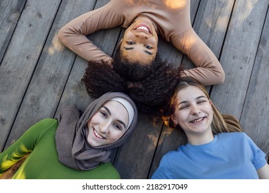 Multiracial young teen female friends resting in the park after sport training laughing and having fun together. Diversity, sport and friendship concept - Powered by Shutterstock