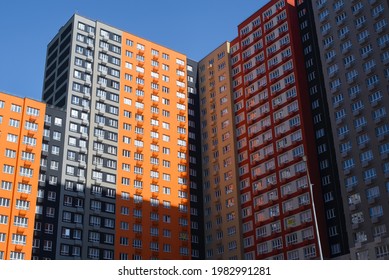 Multi-storey buildings outside. Residential apartment complex, bottom-up view. Multicolored modern buildings during the day.