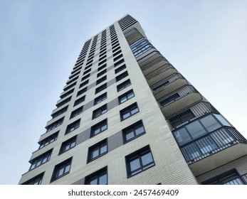 Multi-storey high-rise building with balconies on a blue sky background. - Powered by Shutterstock