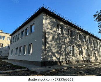 Multistory building facade with sunlight and tree shadows creating a pattern