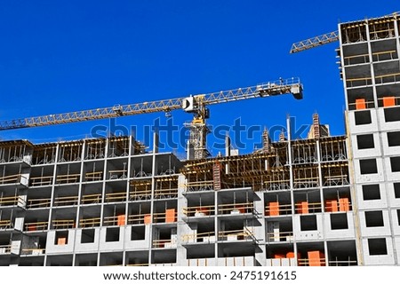 Multistory construction site with crane and blue sky