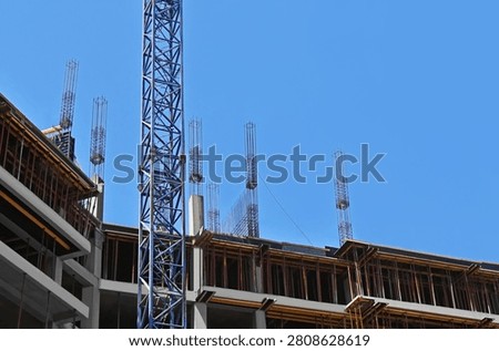 Multistory construction site with crane and blue sky