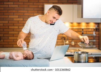 Multitasking Father Feeding His Baby While trying Working on laptop and cooking - Powered by Shutterstock