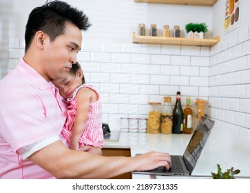 Multi-tasking, Freelance And Fatherhood Concept - Working Asian Father With Baby Daughter And Laptop Computer At Home Office. Dad Working On Laptop While His Baby Girl Sleeping.