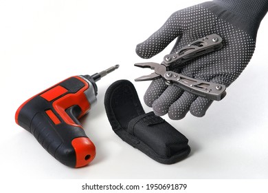 Multi-tool. A Man Disassembles Folding Pliers. In The Background, An Electric Screwdriver. A Home Tool For Small Home Repairs.