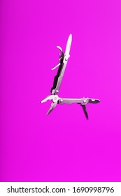 Multitool is a multi-functional tool on a pink background. The concept of an open, flying multi-tool with free space.