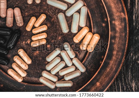 Multivitamin pills on a clay plate, on a vintage wooden table Stock fotó © 