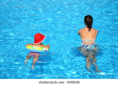 Mum and the daughter float in pool