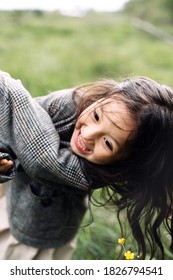 Mum And Daughter Having Fun Together Outdoors In Green Field. Smiling Mother Holding Hands Her Pretty Little Daughter. 