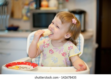 Mum feeds with a spoon her small daughter on background - Shutterstock ID 142678435