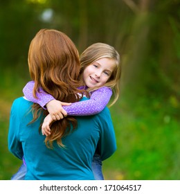 Mum Holding Daughter Kid Girl In Her Arms Rear View Smiling In Outdoor