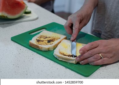 Mum making vegemite sandwich on white slice bread