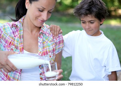 Mum Pouring Out A Glass Of Milk For Her Son