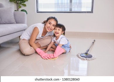 mum teaching daughter cleaning their home living room at weekend. A young woman and a little child girl dusting. family housework and household concept. - Powered by Shutterstock