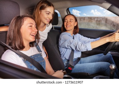 Mum and two teenage daughters on road trip in car - Powered by Shutterstock