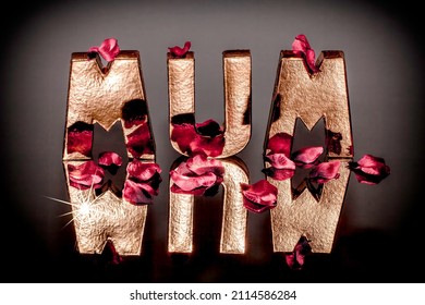 Mum. The Word Mum In Solid Gold With Reflection And Red Rose Petals. Carved Block Letters With Lens Flare Sparkle.  Mothers Day Or Birthday Card Image.