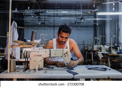 MUMBAI, INDIA - 12 JANUARY 2015: Indian Worker Sowing In A Clothing Factory In Dharavi Slum