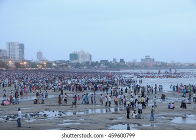 Mumbai, India - 14 SEPTEMBER 2015 - Crowds on the beach watching devotees pushing Hindu God Ganesha into the ocean