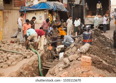 Mumbai, India - 2/2/2011:  A Construction Crew Installing A Sewer Pipe On A Street In Mumbai