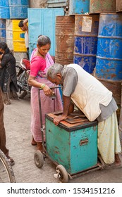 Mumbai, India - 2/2/2011:   An Indian Woman Purchasing An Ice Cream Bar From A Vendor In A Back Alley In The Dharavi Slum Area In Mumbai, India