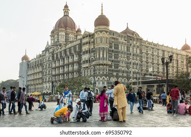 MUMBAI, INDIA - APRIL 14, 2017: A Family Taking Instant Photo Printing Service On The Square Of The Wellington Pier Near The Gateway Of India Mumbai, With The Taj Mahal Palace Hotel In The Background.