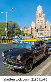 MUMBAI, INDIA - DECEMBER 11: Taxis Drive On A Street On December 11, 2012 In Mumbai, India. The Architecture Of Mumbai Blends Gothic, Victorian, Art Deco And Indo-Saracenic Architectural Styles.