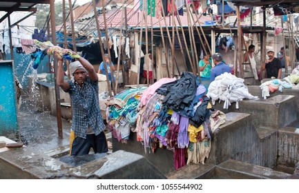 MUMBAI, INDIA - JANUARY 12, 2016: Indian Worker Washing Clothes At Dhobi Ghat, Open Air Laundromat In Downtown Of Mumbai In Maharashtra State