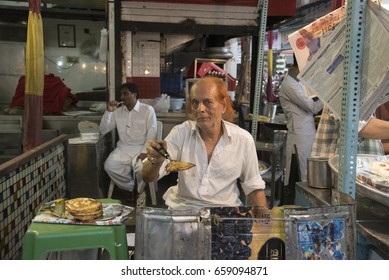 Mumbai, India - July 3, 2015 : Muslim Male Vendors Cookinh And Selling Fried Roti Bread Pancake From Roadside Bakery Shop At Night Market During Holy Month Of Ramadan Ramazan