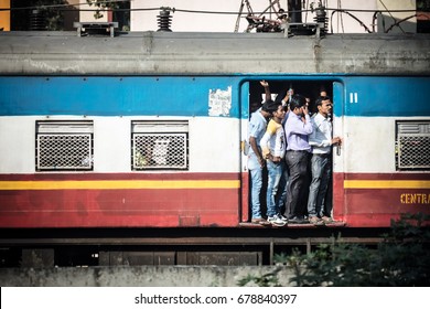 MUMBAI, INDIA - November 10 2017: Commuters On A Crowded Train Hang At The Door Of An Old Train In Mumbai, India