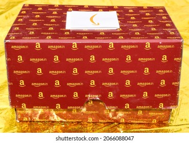 Mumbai, India - October 29, 2021: Close-up Of Amazon Gift Box Isolated On Golden. Amazon Gift Box With A Greeting Card Is Delivered.