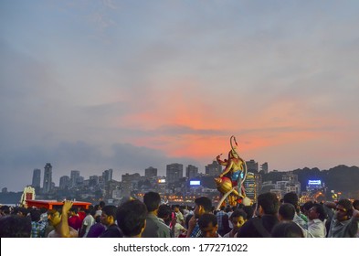 Mumbai, India - September 17, 2013 - Devotee bringing Hindu God Ganesha into the ocean during Ganesha Festival