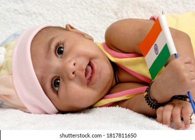 Mumbai, Maharashtra, India, Asia, April. 15, 2007 - Indian Asian cute little newborn baby girl holding tricolour Indian flag on white background; Independence day/Republic day