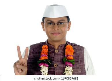 Mumbai; Maharashtra; India- Asia; Dec. 26, 2009 - Portrait of young handsome smiling Indian politician showing victory sign on white background