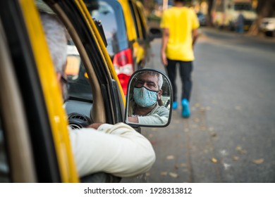 Mumbai, Maharastra, India - 24th February 2021 - A Taxi Driver With His Mask On Looks Through His Side View Mirror