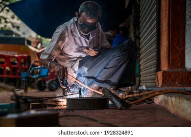 Mumbai, Maharastra, India - 24th February 2021 - A Old Man Busy Welding As His Work Goes On Streetside