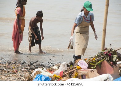 MUMBAI,INDIA, 23 SEPTEMBER 2010 : Group Of Unidentified Young Students Helping One Another To Clean Up The Chaupati Beach In South Mumbai After Hindu Festival Of Immersion Of Ganesha Into The Sea Ends