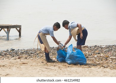 MUMBAI,INDIA, 23 SEPTEMBER 2010 : Group Of Unidentified Young Students Helping One Another To Clean Up The Chaupati Beach In South Mumbai After Hindu Festival Of Immersion Of Ganesha Into The Sea Ends