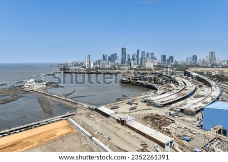 MUMBAI-INDIA - APRIL 2, 2021: The city skyline is seen beside a construction site of a coastal road project near Haji Ali mosque.