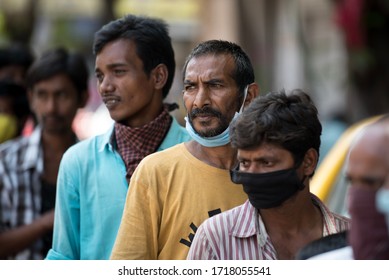 MUMBAI/INDIA - APRIL 7, 2020: Homeless And Unemployed People Stand In Queue To Receives Food And Water During The Nationwide Lockdown As A Preventive Measure Against The COVID-19 Coronavirus.