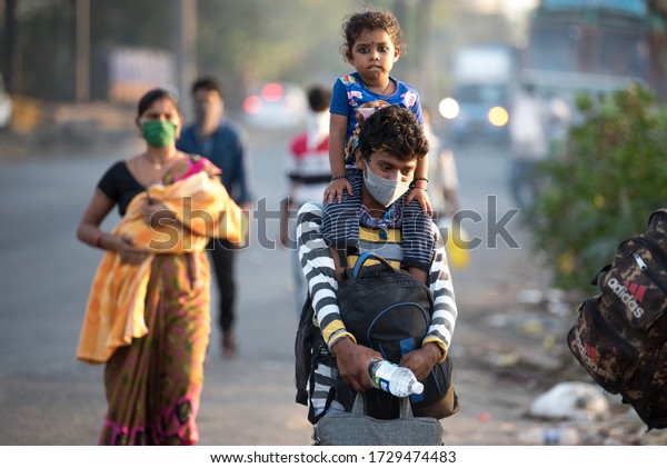 MUMBAI/INDIA - MAY 11, 2020:\
Migrant workers walk on the highway on their journey back home\
during a nationwide lockdown to fight the spread of the COVID-19\
coronavirus.